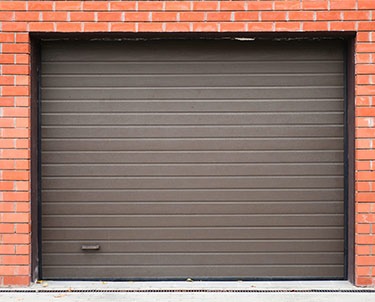 Porte de garage marron sur mur de briques