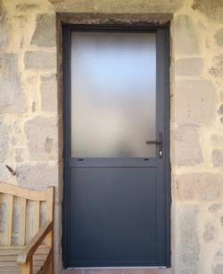 porte d'entrée sombre sur mur de pierre