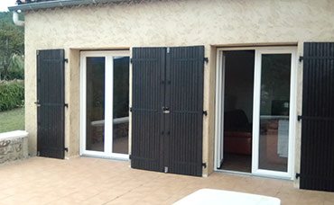 Doubles portes-fenêtres avec volets battants noirs